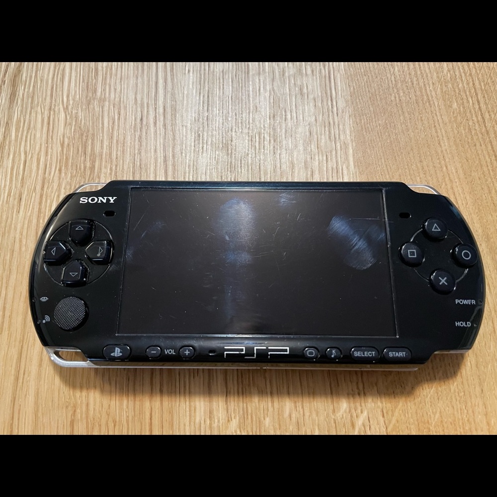 PSP 3000 with case, charger, and one game